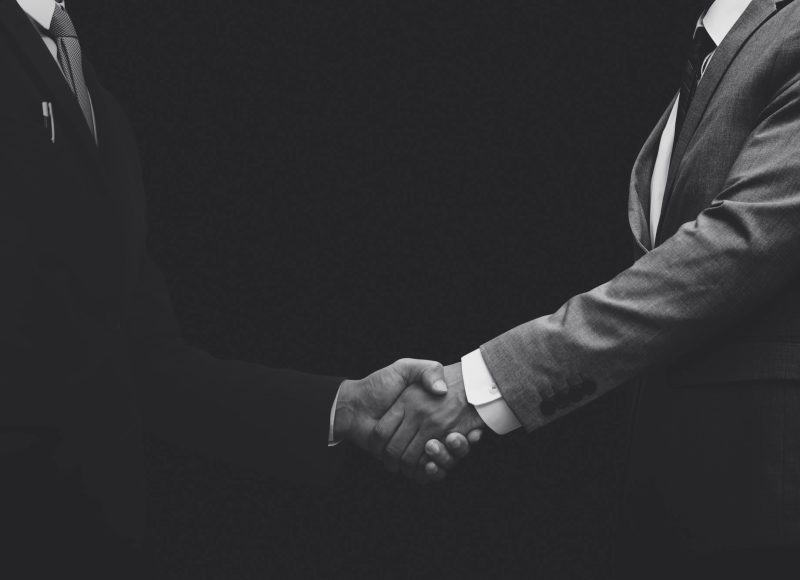 business-partners-shaking-hands-monochrome